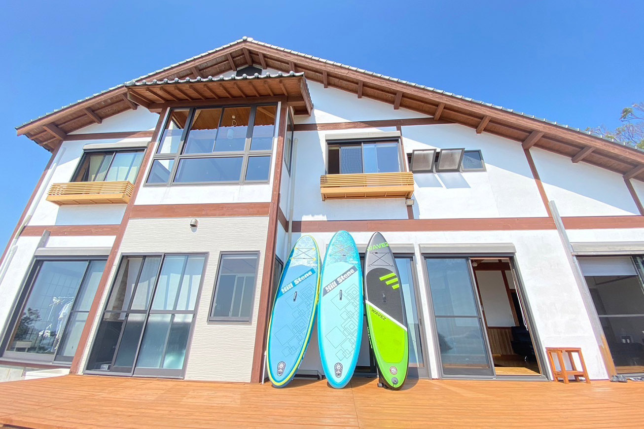 サーフボードを片手に美しく輝く海へ